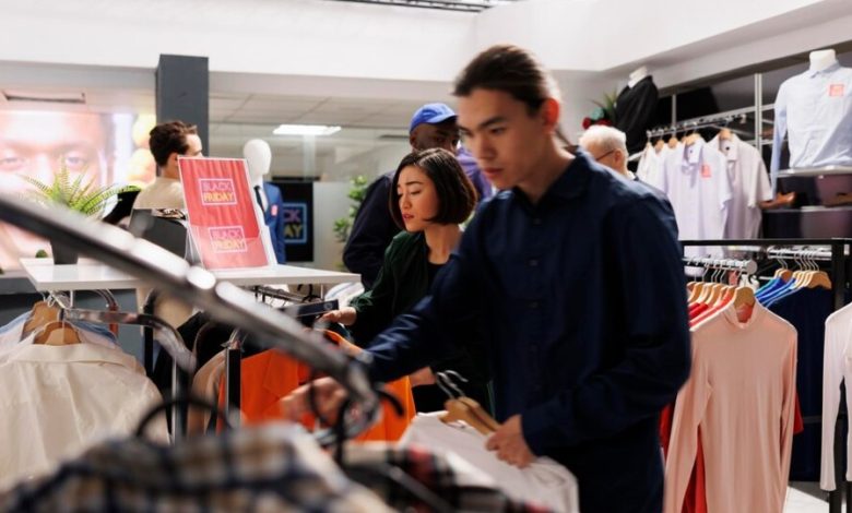 hombre y mujer mirando las perchas de un local de ropa