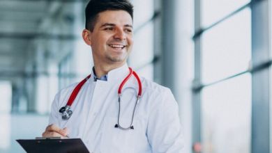 Un médico agarrando su anotador, sonriendo